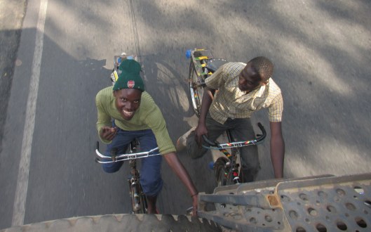 Two cyclists "hitching" a ride as we drive out of Kigali into the mountains